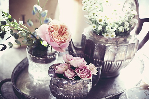 Old metal teapots filled with flowers