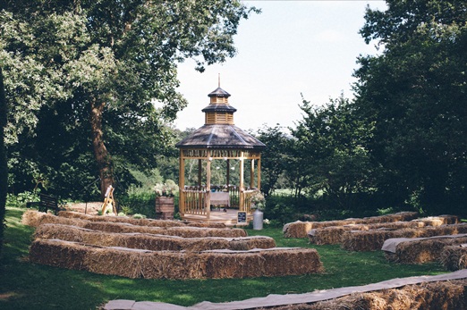 Outdoor wedding ceremony with hay bale seating