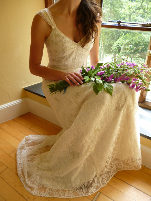 Bride in a lace wedding dress with bouquet of foxgloves