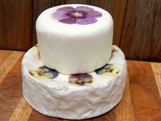 Base of Brie decorated with violas and goat's cheese on top decorated with dianthus from The Edible Flower Shop http://www.theedibleflowershop.co.uk/ 