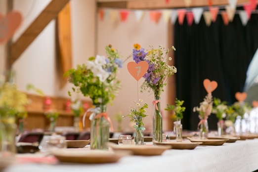 Flowers in vintage bottles and heart table numbers – photography http://www.rebeccaroundhill.co.uk/ 