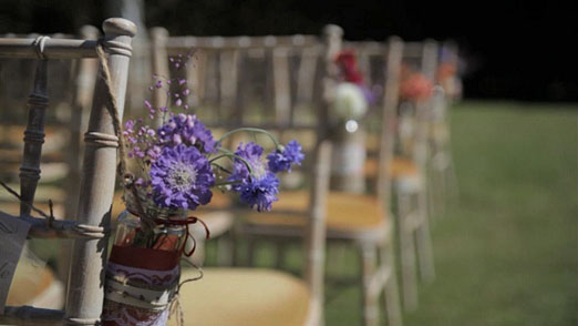 Jam jars of scabious hanging on ceremony chairs – photography http://www.brightstarfilms.co.uk/