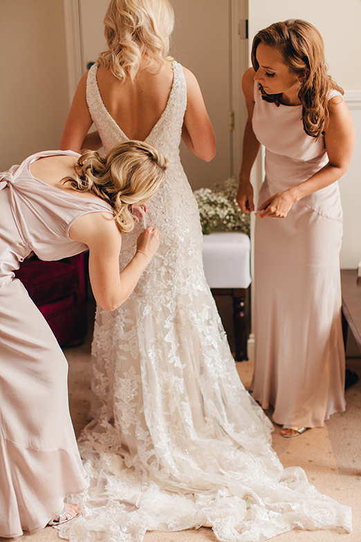 Low backed lace wedding dress and bridesmaids in long blush dresses – photography http://www.bohemianweddings.co.uk/