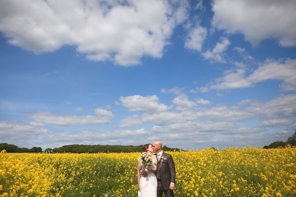 Bride and groom in a meadow of yellow flowers // Taylor Wolf Photography