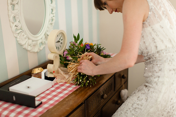 Bride tying wedding bouquet // Bohemian Weddings // The Natural Wedding Company