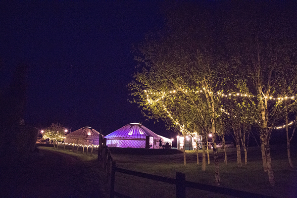 Yurts lit up at night // Jennie Hill Photography // The Natural Wedding Company