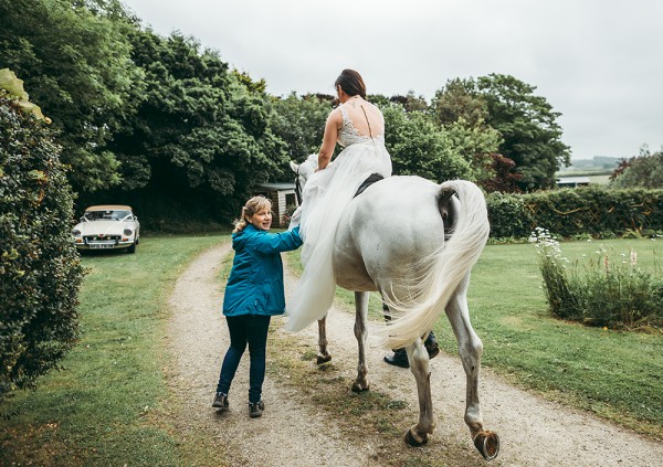 Bride riding a grey horse to a garden tipi wedding // Tracey Warbey Photography // The Natural Wedding Company